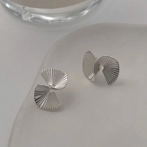 Macro detail of S925 sterling silver fan earrings with matte pleated spiral texture