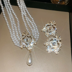 Détail macro d'un collier de perles à quatre rangs et boucles d'oreilles diamants assorties