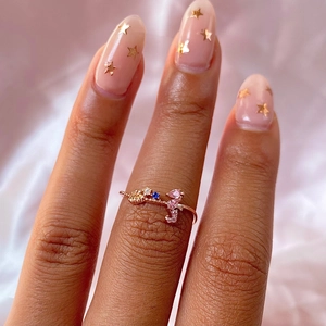 Detail of rose gold sea animal ring with colorful zircons on pink silk background