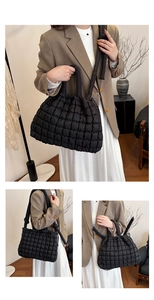 Detail view of black quilted puffer tote bag showing large capacity and soft padded texture