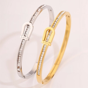 Detail of silver and gold titanium steel bracelets with pave zircon inlay and Love engraving