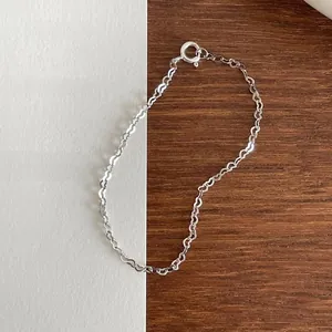 Close-up of S925 sterling silver minimalist heart woven chain bracelet with spring clasp