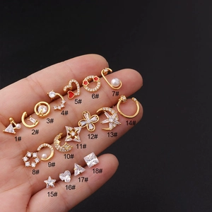 Detailed collection of 18 golden stud earrings with zircon and enamel on a black background