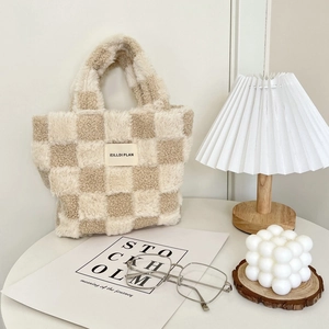Plush checkerboard bucket bag in cream and beige displayed in minimalist aesthetic setting