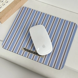 Striped fabric mouse pad with vintage tag on minimalist office desktop setup