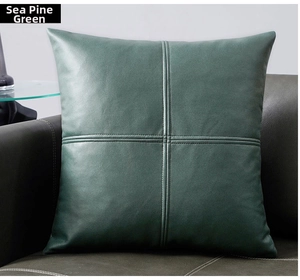 Detail of sea pine green faux leather pillow cover with elegant cross-stitch design