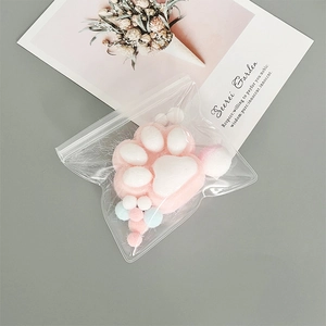 Pink and white cat paw plush in transparent EVA self-sealing bag on a desk