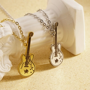 Elegant gold and silver guitar pendant necklaces displayed on classic white pillars
