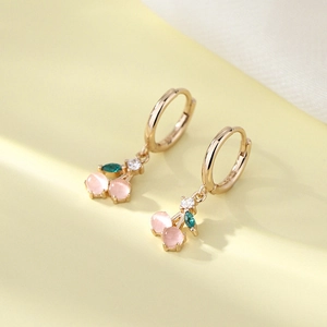 Close-up of S925 silver cherry earrings with pink cat eye stones and green leaf gems