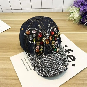 Detailed shot of dark blue denim baseball cap featuring colorful rhinestone butterfly