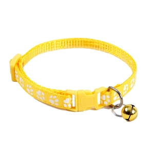 Bright yellow nylon pet collar with white paw prints and a golden bell on white background