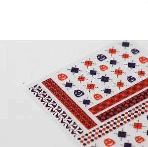 Macro detail of 5D Halloween nail stickers with orange pumpkins and geometric stripes