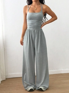 Detail of grey knitted halter neck jumpsuit featuring high waist and wide leg silhouette