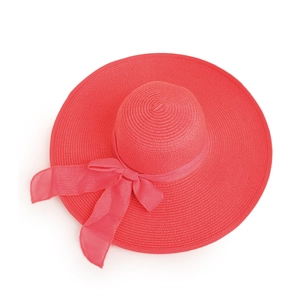 Detailed close-up of rose red woven sun hat featuring a large chiffon bow decoration