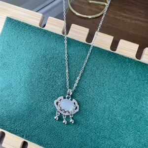 Macro shot of silver Ruyi cloud lock pendant with cat eye stone and metal beads