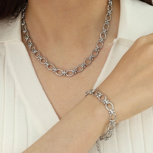 Classic silver titanium steel chain link necklace and bracelet set worn by a fashion model
