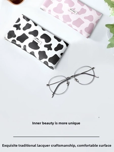 Flat lay of cow print leather glasses pouches with thin metal round frame sunglasses