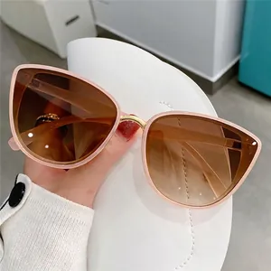 Women's cat eye sunglasses with light pink frames and brown gradient lenses