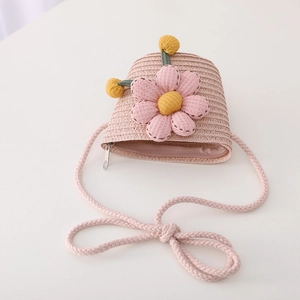 Detailed view of pink straw crossbody bag with floral decoration and zipper for kids