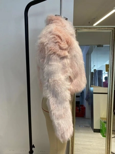 Vue latérale détaillée d'un manteau en fausse fourrure rose avec texture pelucheuse