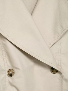 Detailed close-up of khaki trench coat collar featuring twill fabric and tortoise buttons