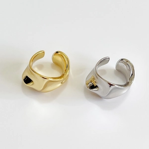Irregular textured silver and gold open rings set against a minimalist white background
