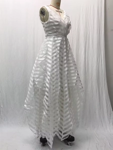 Dettaglio di abito da sposa bianco con motivi strutturati orizzontali e a spina di pesce