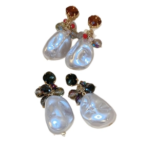 Baroque irregular pearl drop earrings with amber and green stones on white background