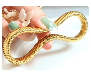 Macro shot of flexible gold-plated omega chain bracelet with a high-polished mirror finish