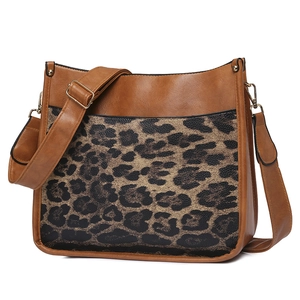 Detail shot of brown faux leather crossbody bag with leopard print panel and shoulder strap