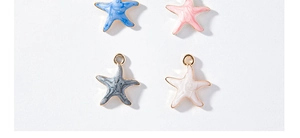 Top view of mini starfish charms with colorful enamel texture and gold metal edges