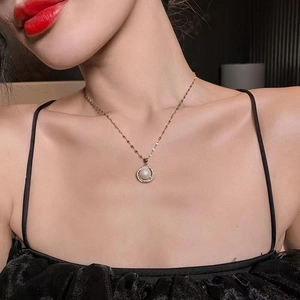Close-up of elegant gold necklace with pearl and diamond pendant on model's neck