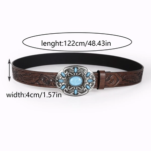 Detail of vintage brown leather belt featuring embossed patterns and blue gemstone buckle