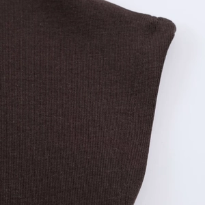 Gros plan sur la texture du tissu en maille marron foncé de la robe à col montant