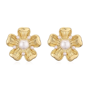 Detailed view of French vintage gold flower earrings featuring centered pearls on white background