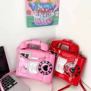 Detail of creative vintage telephone shaped bags in pink and red glossy faux leather