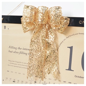 Detail view of large champagne gold sequined bow with sparkling metallic finish