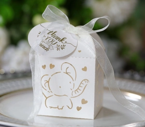Detail of white elephant candy box with golden print, silk ribbon and thank you tag