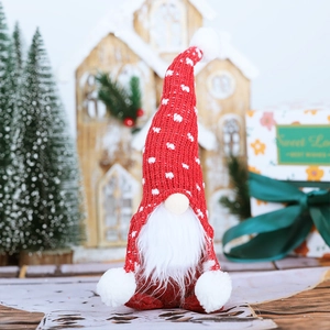 Christmas gnome doll with red knitted hat and white beard in a festive scene