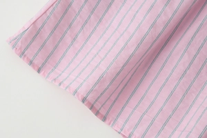 Détail du tissu en coton à rayures roses et grises avec couture d'ourlet professionnelle