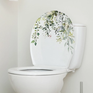 Close-up of watercolor eucalyptus plant stickers applied on a white ceramic toilet lid
