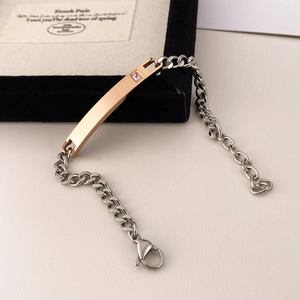 Close-up of silver chain bracelet with rose gold bar detail and pink diamond inlay