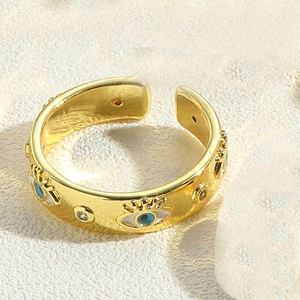 Close-up of gold-plated evil eye ring with blue enamel and clear cubic zirconia details