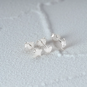 Macro shot of S925 sterling silver stud earrings featuring star, heart, and marquise gemstone