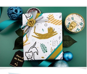 Detail of leopard print gift wrapping paper with decorative grey and mustard yellow ribbons