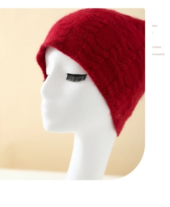 Detailed texture of red knitted cashmere beanie with classic cable knit pattern