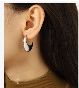 Detailed view of silver water drop earrings worn by a model with a minimalist metal design