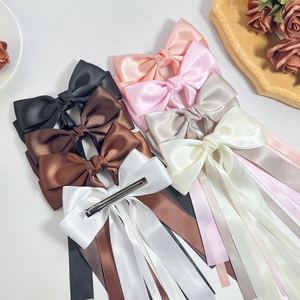 Elegant satin bow hair clips with long ribbons in multiple colors on a clean white background