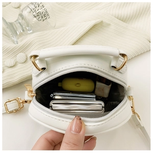 Top view of open white PU leather crossbody bag showing internal space and golden hardware