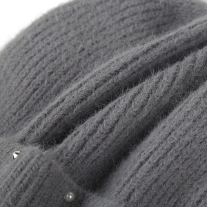 Close-up of gray knit beanie featuring fluffy wool texture with pearls and silver studs
